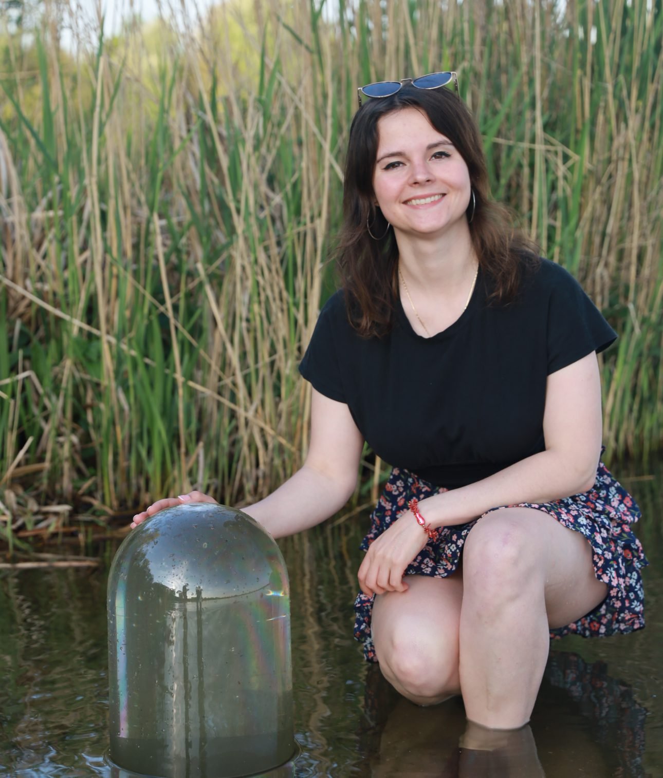 Maria Poretskova, founder of FishView, placing a FishView dome in a pond