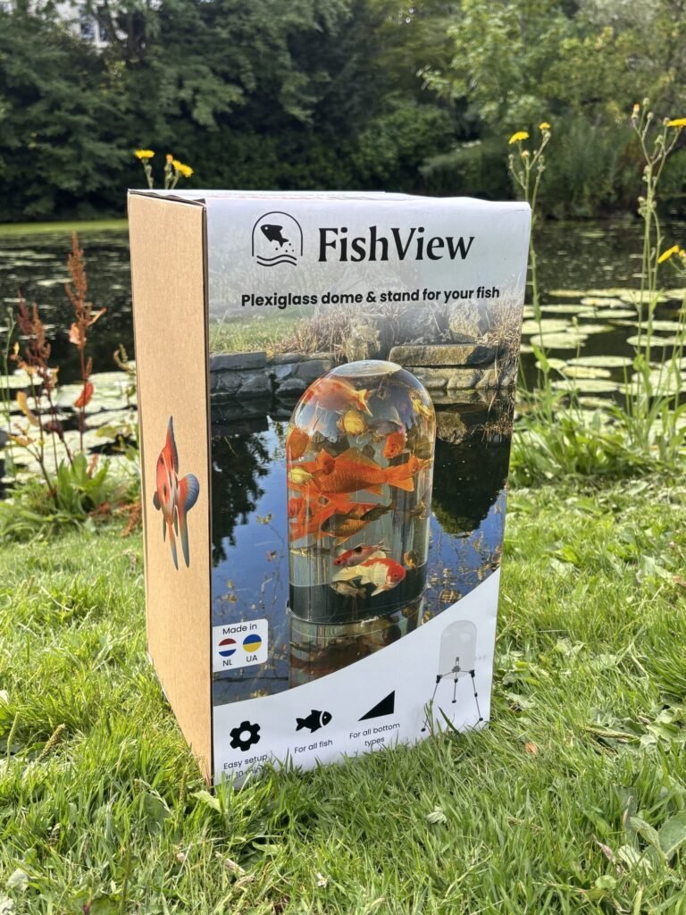 FishView pond dome packaging standing in the grass next to a pond with water lilies